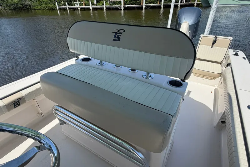 Slide: The Image of 2022 Carolina Skiff 26 Ultra Elite boat interior with cushioned seating and cup holders. - 18