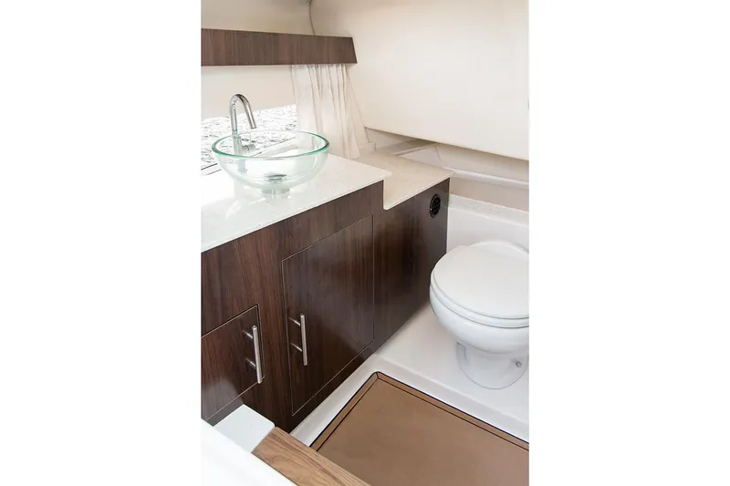 Slide: The Image of Manufacturer Provided Image: Modern bathroom in 2026 Regal 3300 boat with glass sink and wooden cabinetry. - 17