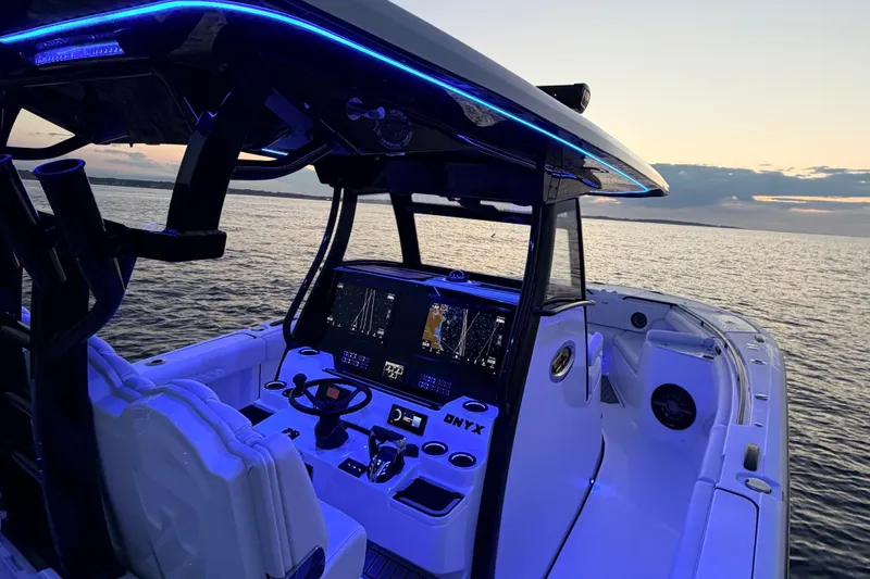 Slide: The Image of The image shows the cockpit of a Tidewater 330 CC Adventure boat at sunset. It features blue LED lighting and modern navigation equipment. - 11