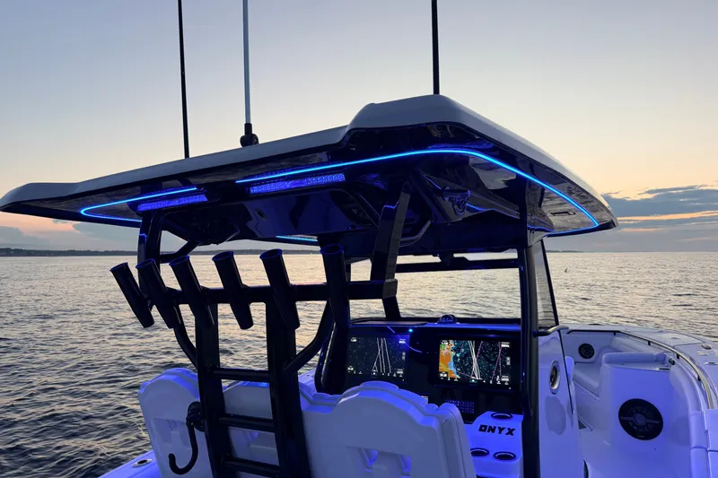 Slide: The Image of 2027 Tidewater 330 CC Adventure boat with illuminated cockpit at sunset on the water. - 16