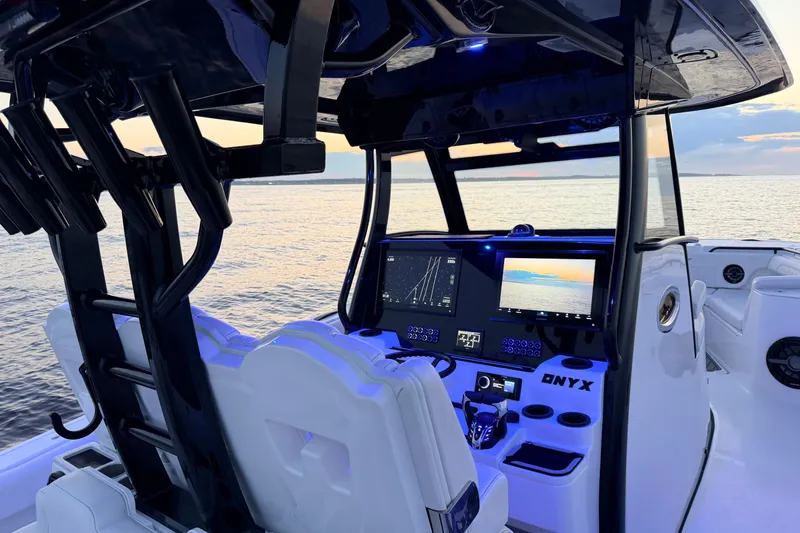 Slide: The Image of 2027 Tidewater 330 CC Adventure boat cockpit with advanced navigation displays at sunset. - 22