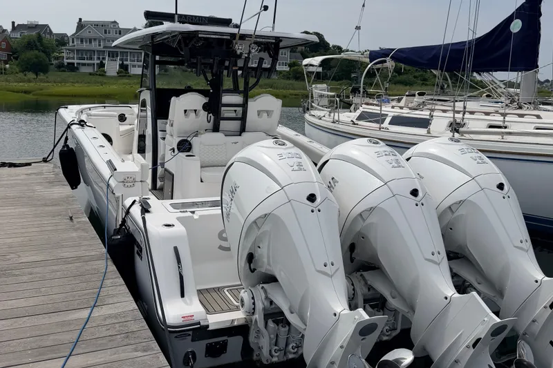 Slide: The Image of A modern boat with three powerful outboard engines docked. It features a sleek design. - 30