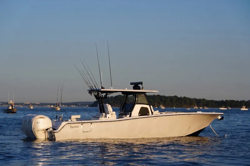 The Image of 2027 Tidewater 330 CC Adventure boat on calm water, equipped for fishing. - 0