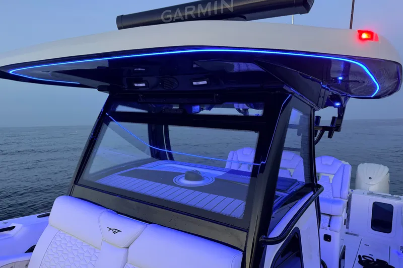 Slide: The Image of 2027 Tidewater 330 CC Adventure boat with illuminated canopy and ocean backdrop. - 5
