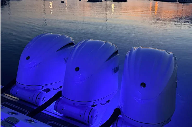 Slide: The Image of Three outboard engines glow blue in the evening light on calm water. - 9