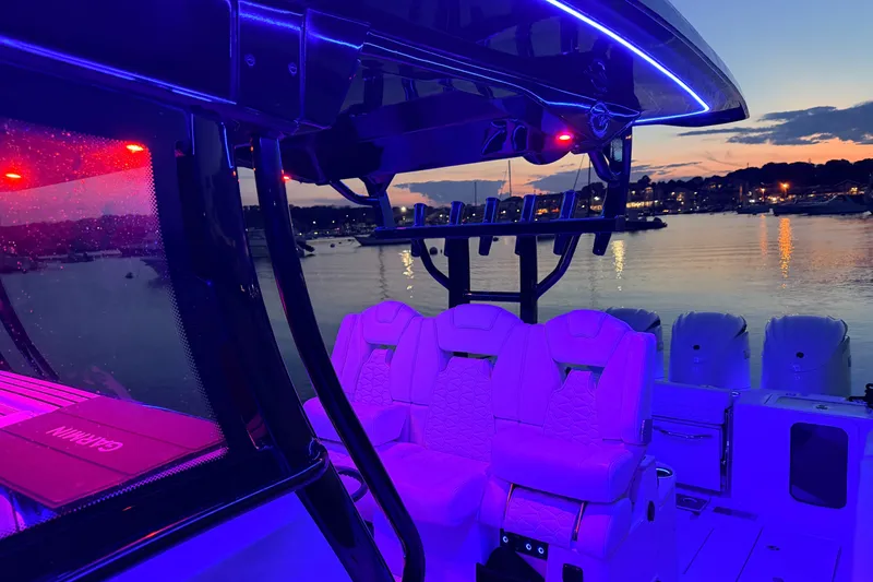 Slide: The Image of 2027 Tidewater 330 CC Adventure boat interior with vibrant LED lighting at sunset. - 6