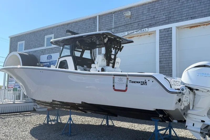 Slide: The Image of 2027 Tidewater 330 CC Adventure boat displayed at a marina, elevated on stands. - 1