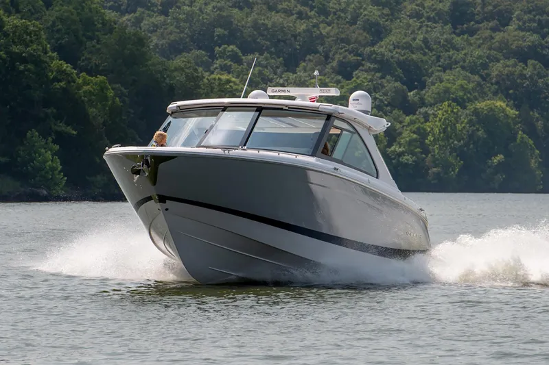 The Image of Manufacturer Provided Image: 2026 Regal LS36 boat cruising on a lake with lush green forest backdrop. - 0