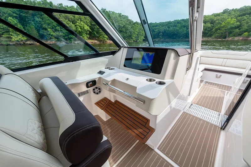 Slide: The Image of Manufacturer Provided Image: 2026 Regal LS36 boat interior with modern dashboard and luxurious seating on a scenic lake. - 15