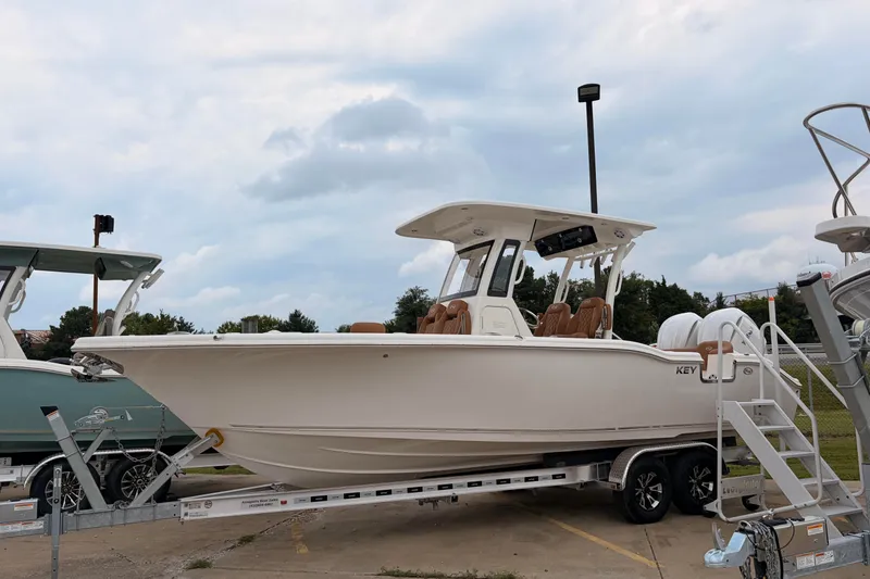The Image of 2026 Key West 263 FS boat on trailer, parked outdoors under cloudy sky. - 13