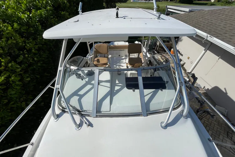 Slide: The Image of 2001 Hydra-Sports Vector 2800 WA boat with canopy and seating, docked near greenery. - 27