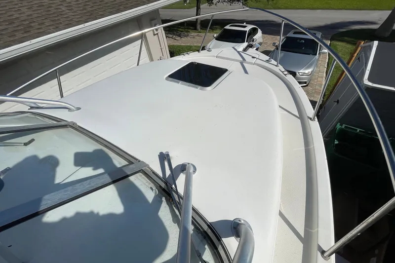 Slide: The Image of 2001 Hydra-Sports Vector 2800 WA boat deck with railing and hatch, parked near cars. - 22