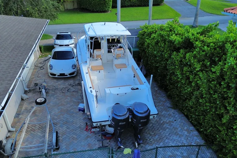Slide: The Image of 2001 Hydra-Sports Vector 2800 WA boat parked beside a house with cars nearby. - 44