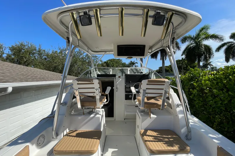 Slide: The Image of 2001 Hydra-Sports Vector 2800 WA boat cockpit with seating and control panel, surrounded by lush greenery. - 30