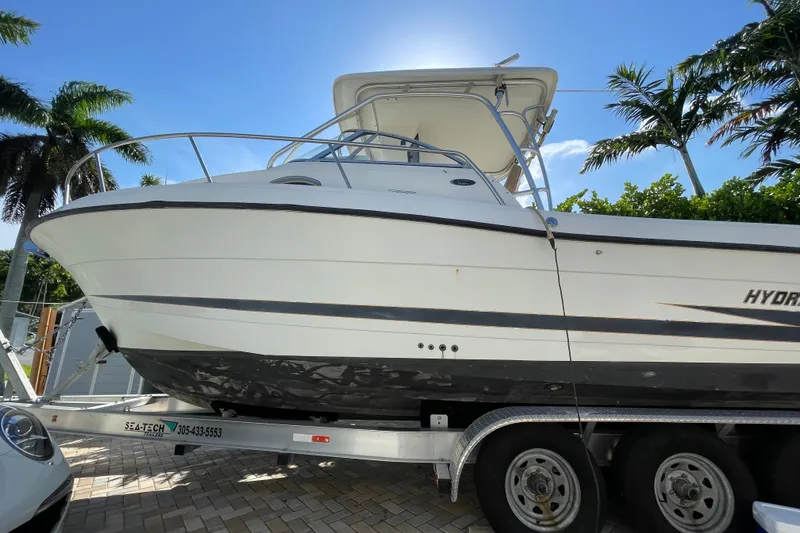 Slide: The Image of 2001 Hydra-Sports Vector 2800 WA boat on trailer, surrounded by palm trees. - 13
