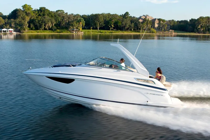 The Image of Manufacturer Provided Image: 2026 Regal 28 Express boat cruising on a serene lake with lush greenery. - 0