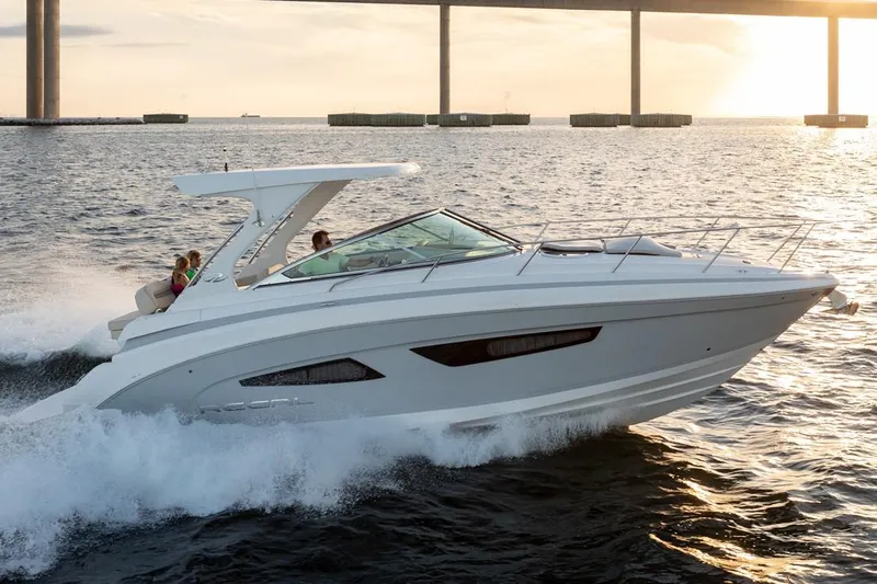 The Image of Manufacturer Provided Image: 2026 Regal 33 Express cruising on water at sunset near a bridge. - 0