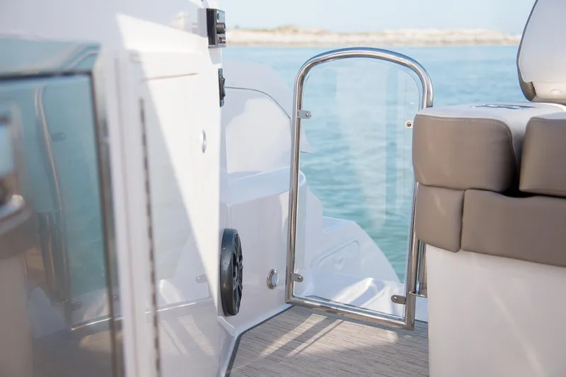 Slide: The Image of Manufacturer Provided Image: 2026 Regal 33 XO boat interior with open glass door and cushioned seating. - 13