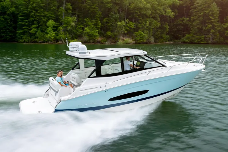 The Image of Manufacturer Provided Image: 2026 Regal 36 Grande Coupe cruising on a lake with lush green forest backdrop. - 0