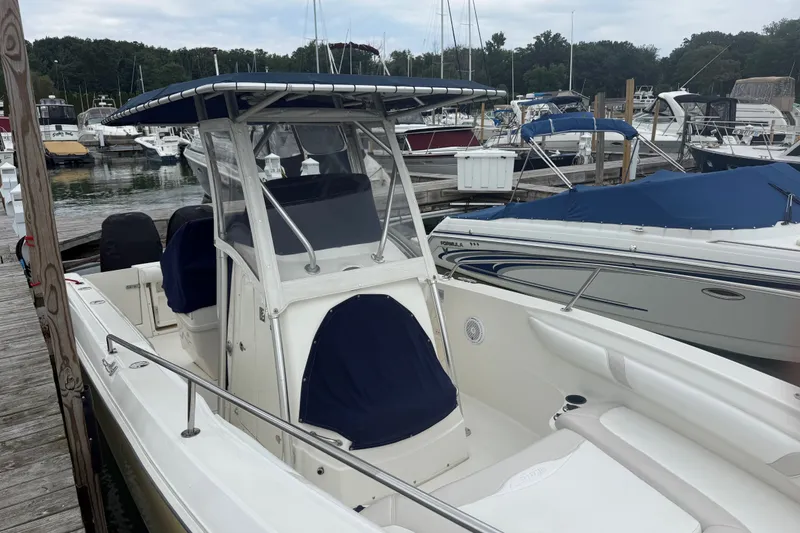 Slide: The Image of 2005 Boston Whaler 270 Outrage docked at marina, surrounded by other boats. - 4