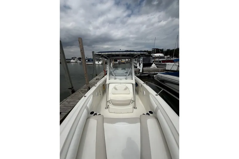 Slide: The Image of 2005 Boston Whaler 270 Outrage docked at marina under cloudy sky. - 9