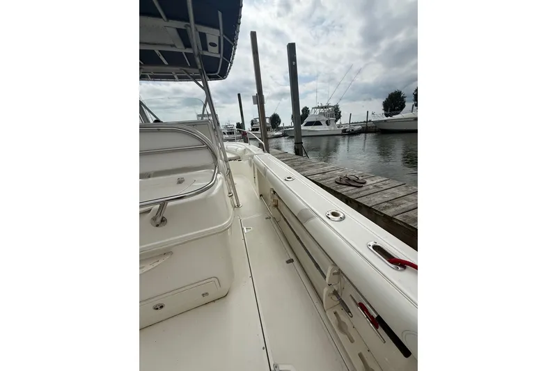 Slide: The Image of 2005 Boston Whaler 270 Outrage docked, showcasing spacious deck and sleek design. - 7