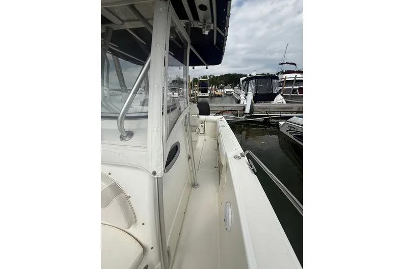 Slide: The Image of 2005 Boston Whaler 270 Outrage docked, showcasing side view and marina background. - 11