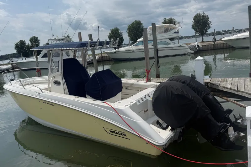 The Image of A 2005 Boston Whaler 270 Outrage docked. It features dual outboard engines. - 0