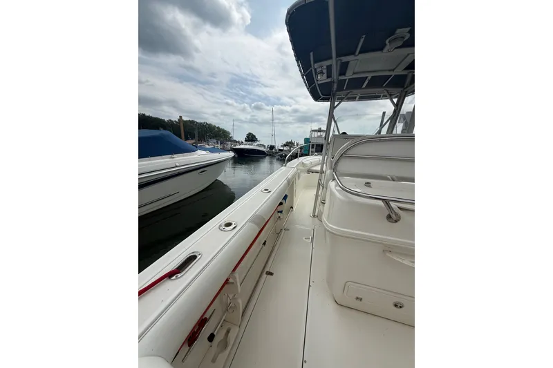 Slide: The Image of 2005 Boston Whaler 270 Outrage boat docked in a marina under cloudy skies. - 8