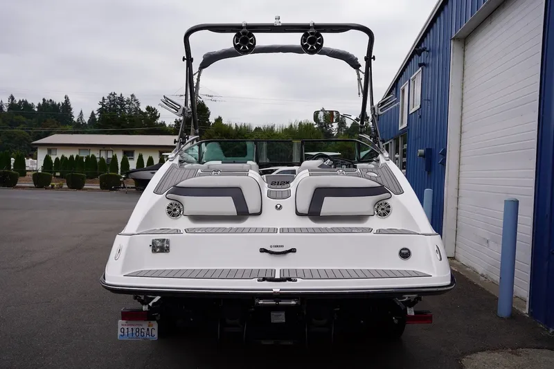 Slide: The Image of 2014 Yamaha Boats 212X, rear view, parked near blue building. - 8