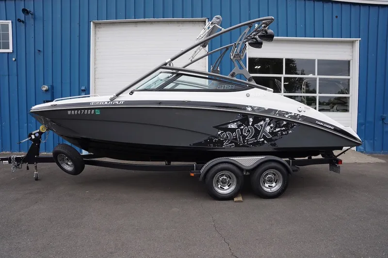 The Image of 2014 Yamaha Boats 212X on trailer, parked outside blue building. - 0