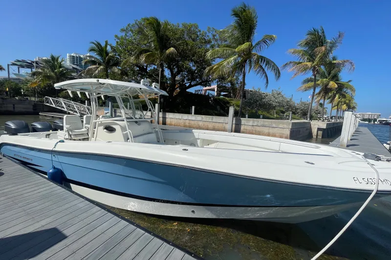 Slide: The Image of 2004 Hydra-Sports Vector 3300 CC boat docked by palm trees under clear blue sky. - 14