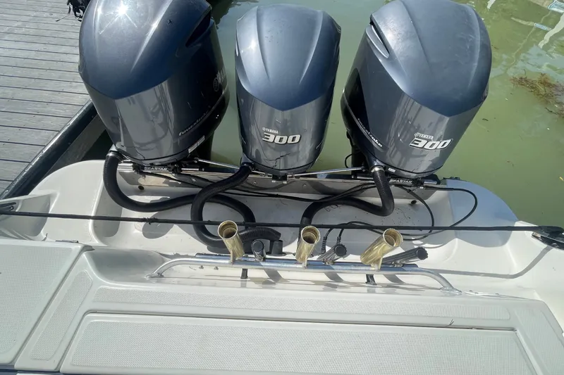 Slide: The Image of Three powerful outboard engines are mounted on the stern of a boat docked at a pier. - 36