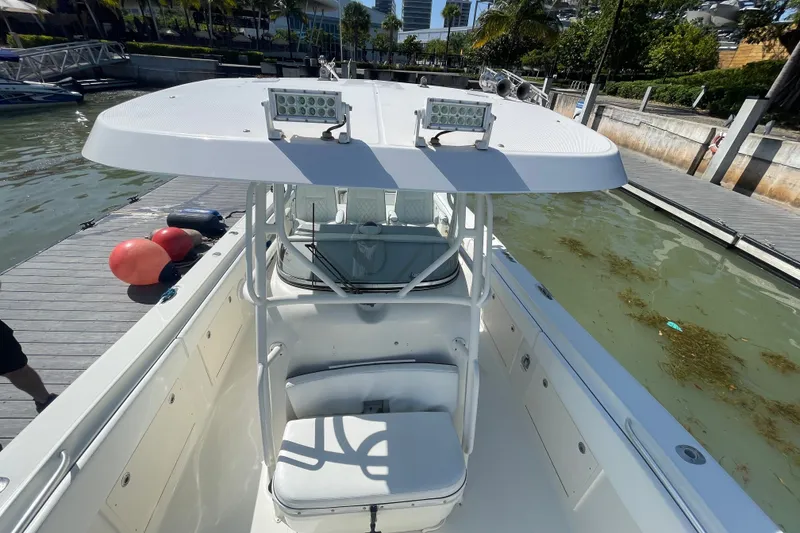 Slide: The Image of 2004 Hydra-Sports Vector 3300 CC boat docked, featuring a spacious deck and overhead lights. - 34