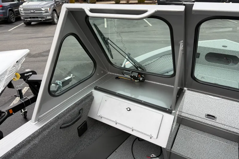 Slide: The Image of 2026 Crestliner 1850 Commander boat interior with windshield and storage compartment. - 9