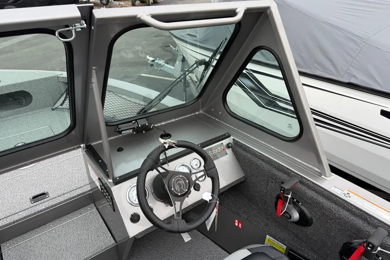 Slide: The Image of 2026 Crestliner 1850 Commander boat cockpit with steering wheel and dashboard controls. - 10