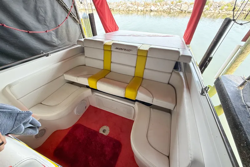 Slide: The Image of Interior of a 2000 Sonic 45 SS boat with white seating and red carpet. - 26