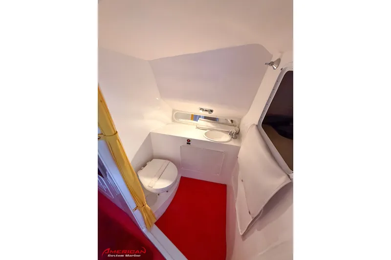 Slide: The Image of Compact bathroom in 2000 Sonic 45 SS boat with red flooring and white fixtures. - 16
