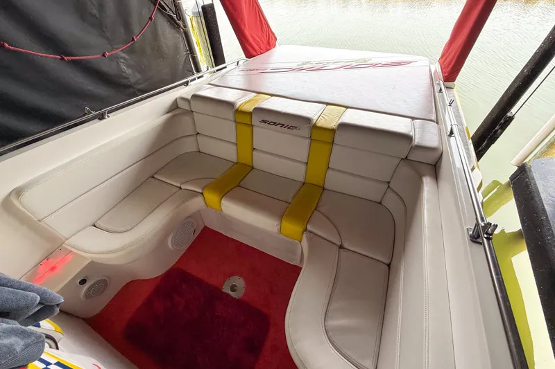 Slide: The Image of Interior of a 2000 Sonic 45 SS boat with white seating and red carpet. - 41