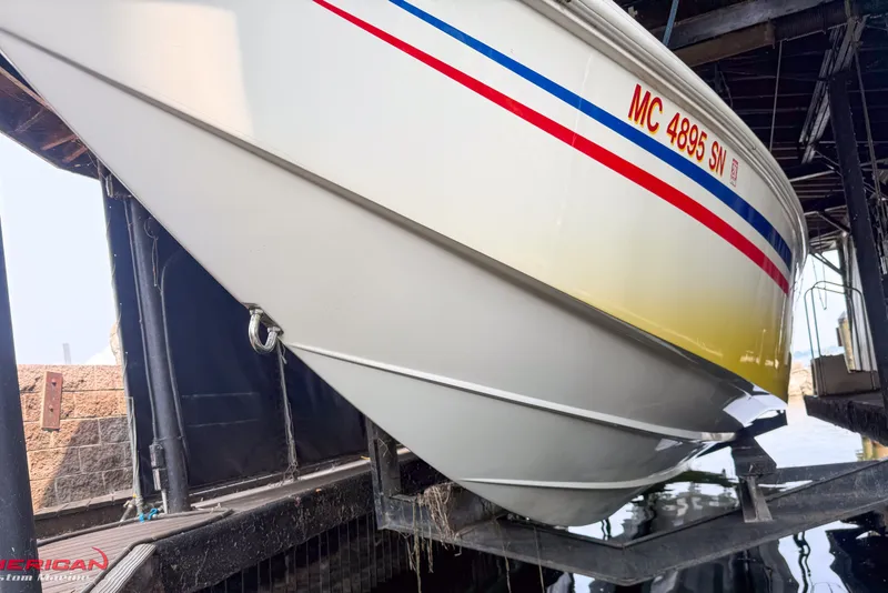 Slide: The Image of 2000 Sonic 45 SS boat in dock, featuring red and blue stripes. - 12