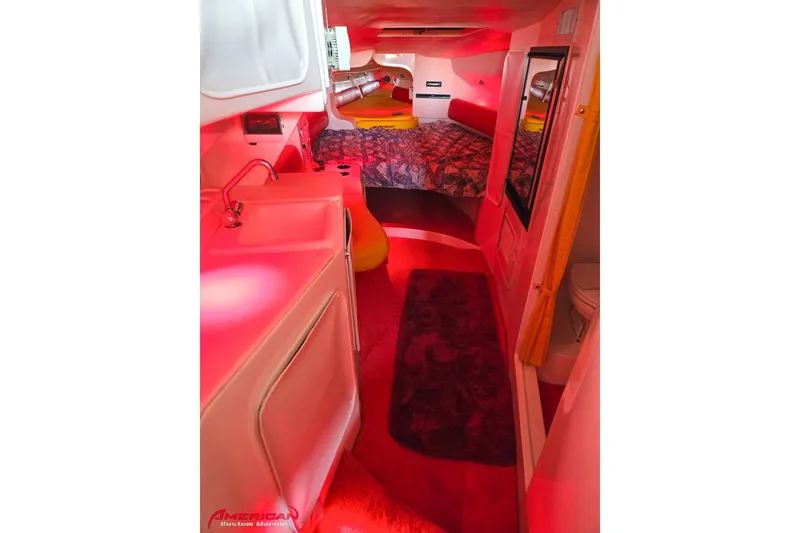 Slide: The Image of Interior of 2000 Sonic 45 SS boat with red lighting, featuring a sink and cozy seating area. - 8