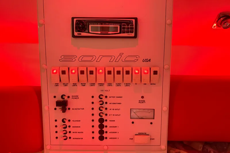 Slide: The Image of Control panel of a 2000 Sonic 45 SS boat, illuminated in red lighting. - 24