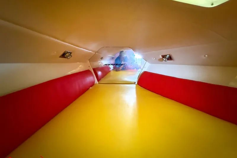 Slide: The Image of Interior of a 2000 Sonic 45 SS boat with vibrant red and yellow seating. - 21