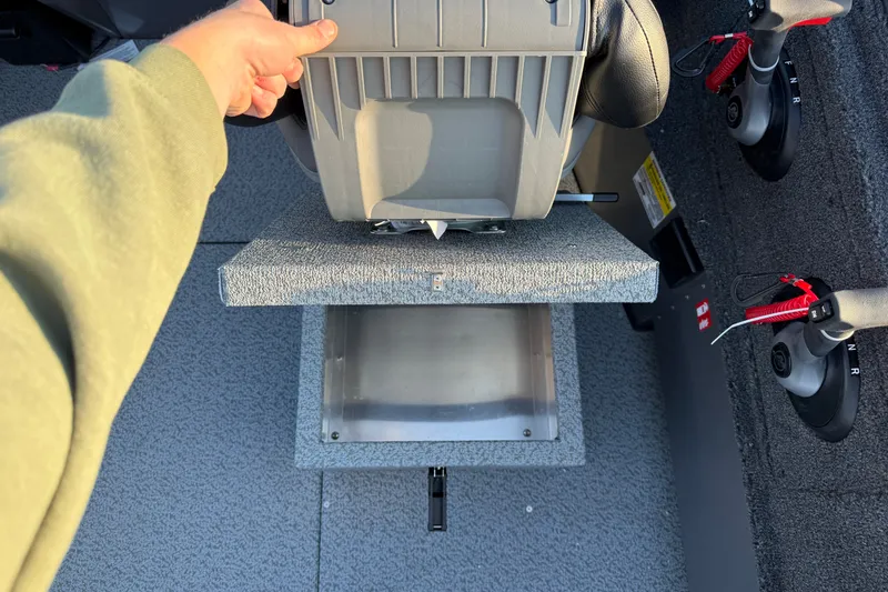 Slide: The Image of Hand lifting seat on 2026 Crestliner 2050 Commander boat, revealing storage compartment. - 9