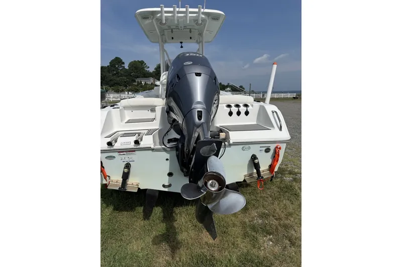 Slide: The Image of 2017 Sea Hunt Ultra 211 boat with outboard motor, parked on grass. - 1