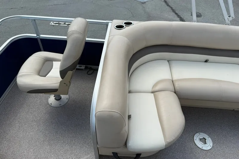 Slide: The Image of 2016 Sun Tracker Fishin' Barge 20 DLX interior with beige seating and cup holders. - 18