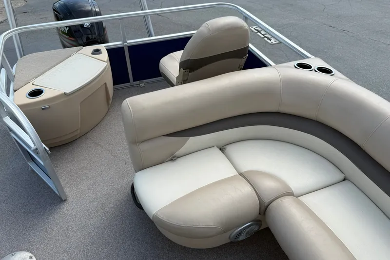 Slide: The Image of 2016 Sun Tracker Fishin' Barge 20 DLX interior with beige seating and cup holders. - 16