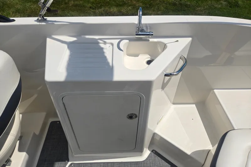 Slide: The Image of 2020 Bayliner DX 2250 boat interior with sink and storage compartment. - 12
