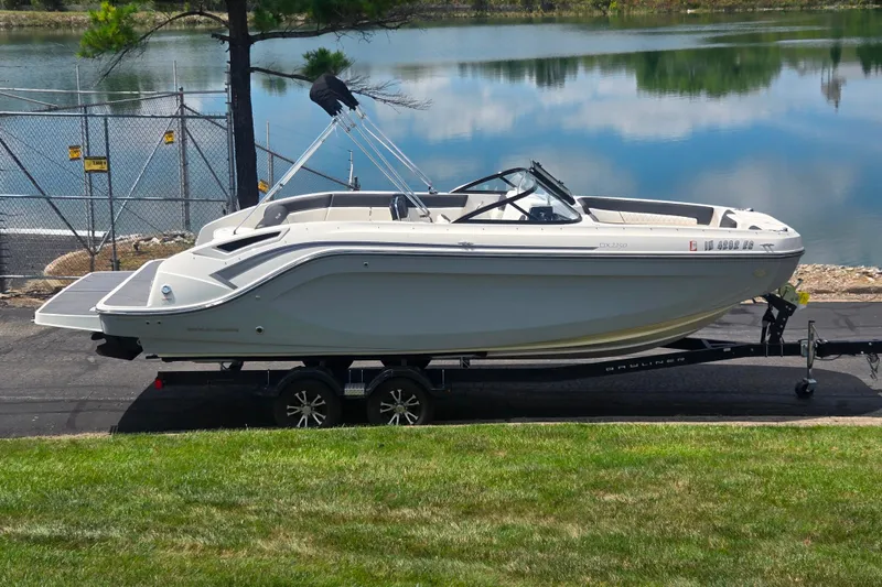 The Image of 2020 Bayliner DX 2250 boat on trailer by a lake. - 0