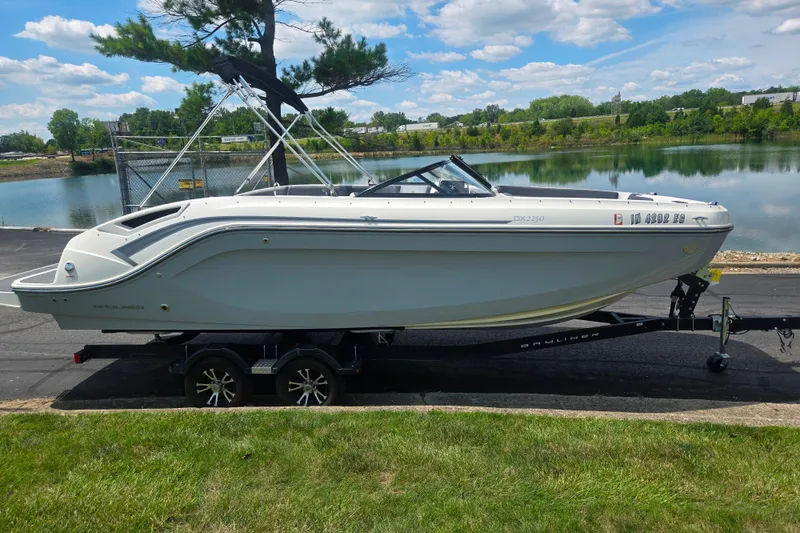 Slide: The Image of 2020 Bayliner DX 2250 boat on trailer by a scenic lake under a blue sky. - 9